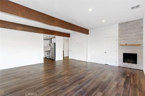 Empty room, Fireplace, Interior, Kitchen, Recessed Lighting, Stone Walls, Wooden Beams, Wood Texture Flooring