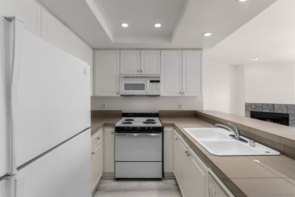 Fireplace, Interior, Kitchen, Recessed Lighting, Tile Countertops, Wood Texture Flooring