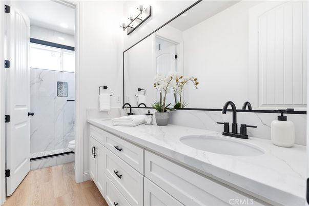 Bathroom, Dual Sink Vanities, Glass Shower, Interior, Marble Walls, Recessed Lighting, Wood Texture Flooring
