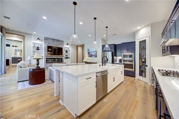 Fireplace, Interior, Kitchen, Living room, Pendant Lights, Recessed Lighting, Stainless Steel Appliances, Stone Walls, Wood Texture Flooring