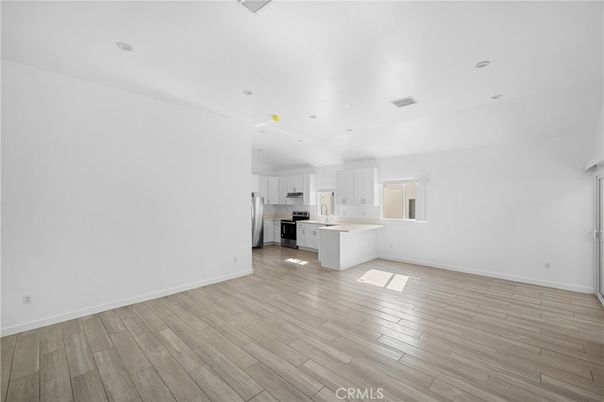 Empty room, Interior, Kitchen, Recessed Lighting, Stainless Steel Appliances, Wood Texture Flooring