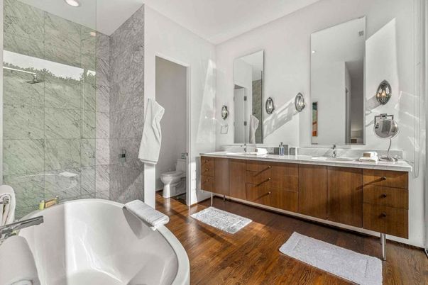 Bathroom, Dual Sink Vanities, Free Standing Baths, Glass Shower, Interior, Marble Walls, Recessed Lighting, Wood Texture Flooring