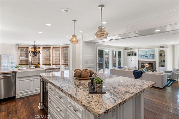 Chandelier, Fireplace, Interior, Kitchen, Living room, Pendant Lights, Recessed Lighting, Stainless Steel Appliances, Wood Texture Flooring