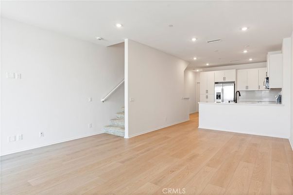 Empty room, Interior, Kitchen, Recessed Lighting, Stainless Steel Appliances, Wood Texture Flooring