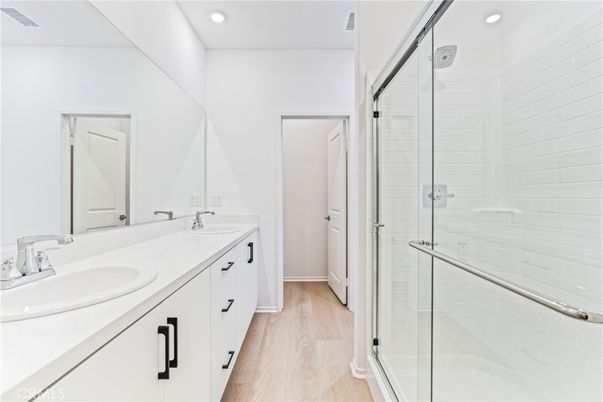 Bathroom, Dual Sink Vanities, Glass Shower, Interior, Recessed Lighting, Wood Texture Flooring