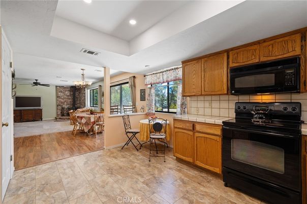 Chandelier, Dining room, Interior, Kitchen, Recessed Lighting, Stone Walls, Tile Countertops, Wood Texture Flooring