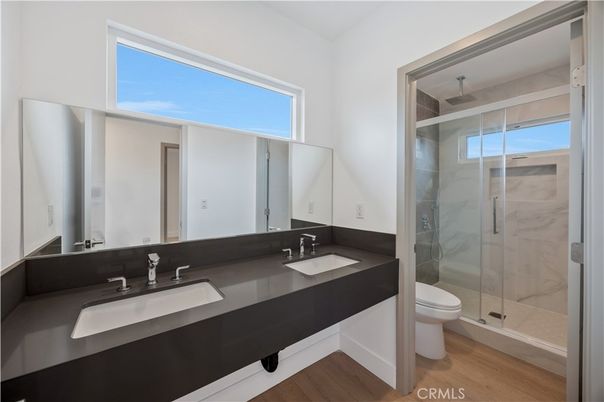 Bathroom, Dual Sink Vanities, Glass Shower, Interior, Marble Walls, Wood Texture Flooring