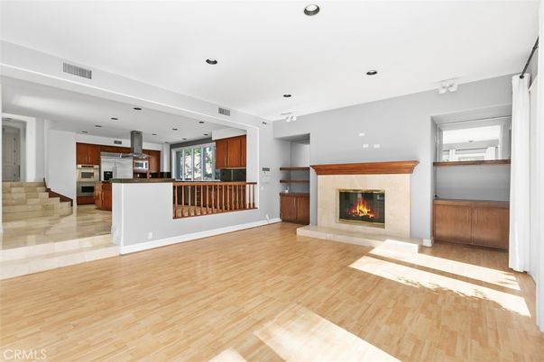 Empty room, Fireplace, Interior, Kitchen, Recessed Lighting, Stainless Steel Appliances, Wood Texture Flooring
