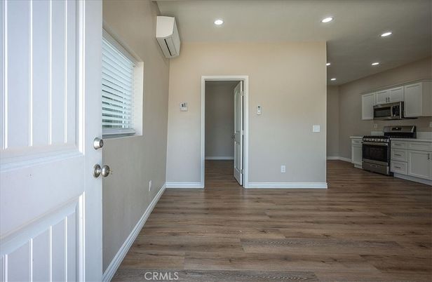 Empty room, Interior, Kitchen, Recessed Lighting, Stainless Steel Appliances, Wood Texture Flooring
