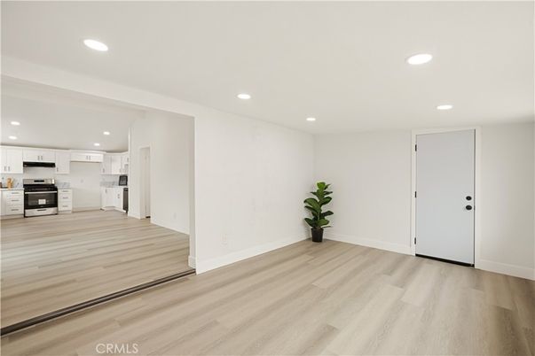 Empty room, Interior, Kitchen, Recessed Lighting, Stainless Steel Appliances, Wood Texture Flooring