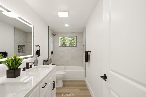 Bathroom, Dual Sink Vanities, Interior, Marble Walls, Recessed Lighting, Wood Texture Flooring