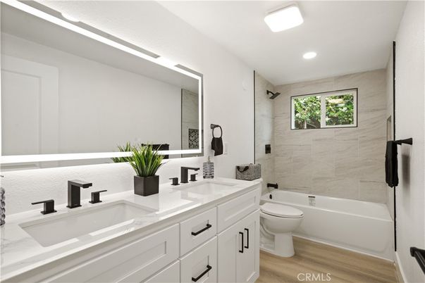 Bathroom, Dual Sink Vanities, Interior, Marble Walls, Recessed Lighting, Wood Texture Flooring