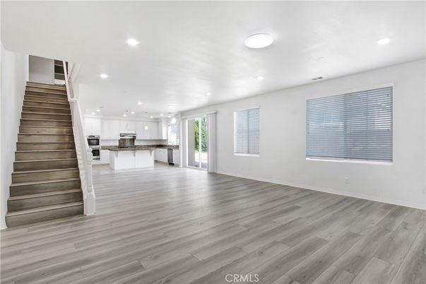 Empty room, Interior, Kitchen, Recessed Lighting, Stainless Steel Appliances, Wood Texture Flooring