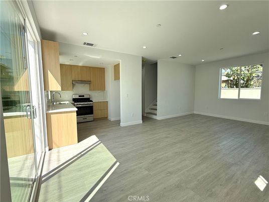 Empty room, Interior, Kitchen, Recessed Lighting, Stainless Steel Appliances, Wood Texture Flooring