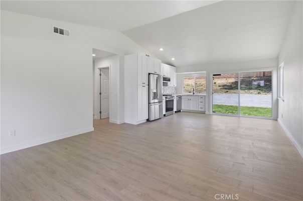 Empty room, Interior, Kitchen, Recessed Lighting, Stainless Steel Appliances, Wood Texture Flooring