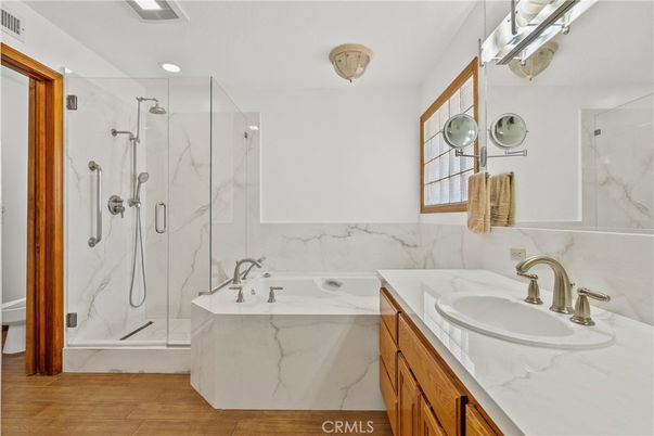 Bathroom, Dual Sink Vanities, Glass Shower, Interior, Marble Walls, Recessed Lighting, Wood Texture Flooring