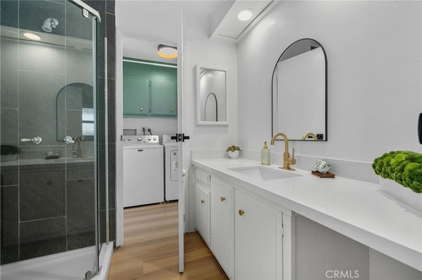 Bathroom, Dual Sink Vanities, Glass Shower, Interior, Recessed Lighting, Washer, Wood Texture Flooring