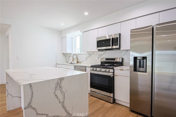 Interior, Kitchen, Marble Walls, Recessed Lighting, Stainless Steel Appliances, Wood Texture Flooring