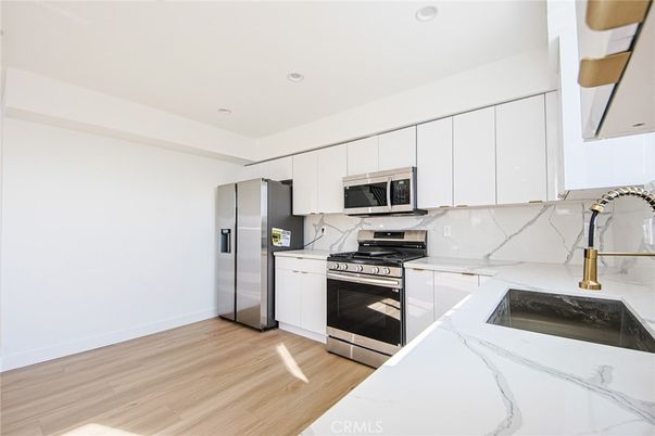 Interior, Kitchen, Marble Walls, Recessed Lighting, Stainless Steel Appliances, Wood Texture Flooring