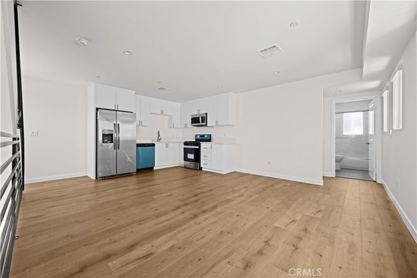 Empty room, Interior, Kitchen, Recessed Lighting, Stainless Steel Appliances, Wood Texture Flooring