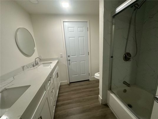 Bathroom, Dual Sink Vanities, Glass Shower, Interior, Marble Walls, Recessed Lighting, Wood Texture Flooring