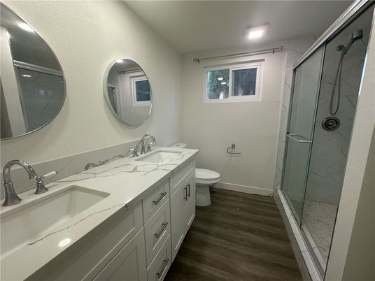 Bathroom, Dual Sink Vanities, Glass Shower, Interior, Marble Walls, Recessed Lighting, Wood Texture Flooring