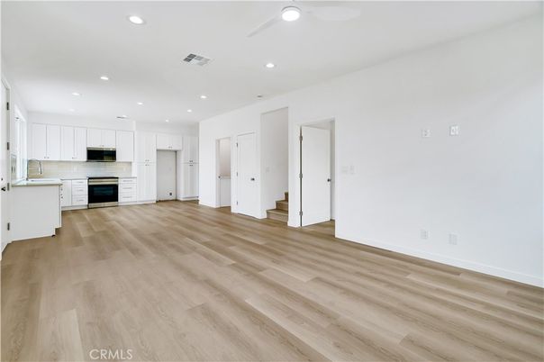 Empty room, Interior, Kitchen, Recessed Lighting, Stainless Steel Appliances, Wood Texture Flooring