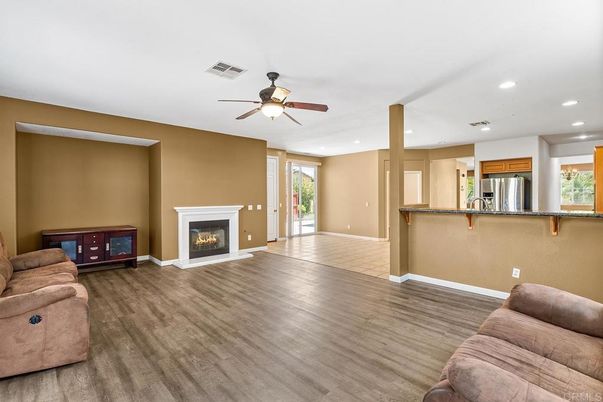 Empty room, Fireplace, Interior, Kitchen, Living room, Recessed Lighting, Stainless Steel Appliances, Wood Texture Flooring