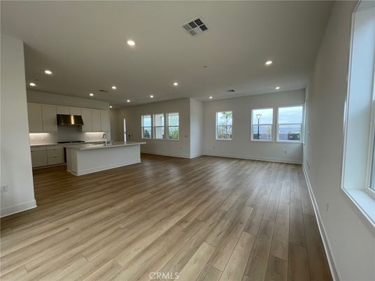 Empty room, Interior, Kitchen, Recessed Lighting, Stainless Steel Appliances, Wood Texture Flooring