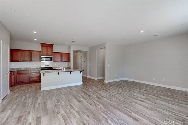 Empty room, Interior, Kitchen, Recessed Lighting, Stainless Steel Appliances, Wood Texture Flooring