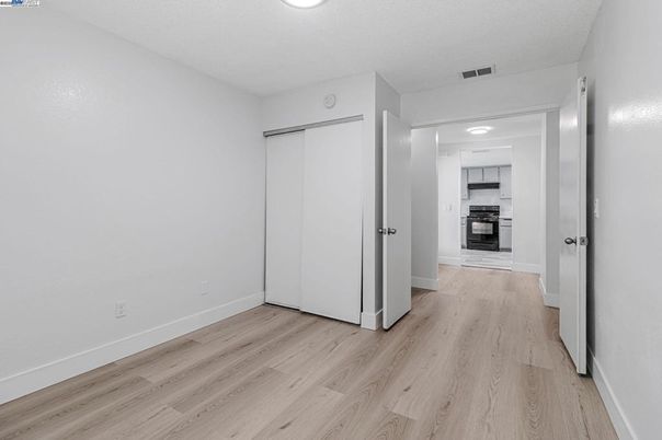 Empty room, Interior, Kitchen, Recessed Lighting, Stainless Steel Appliances, Wood Texture Flooring