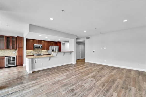 Empty room, Interior, Kitchen, Recessed Lighting, Stainless Steel Appliances, Wood Texture Flooring