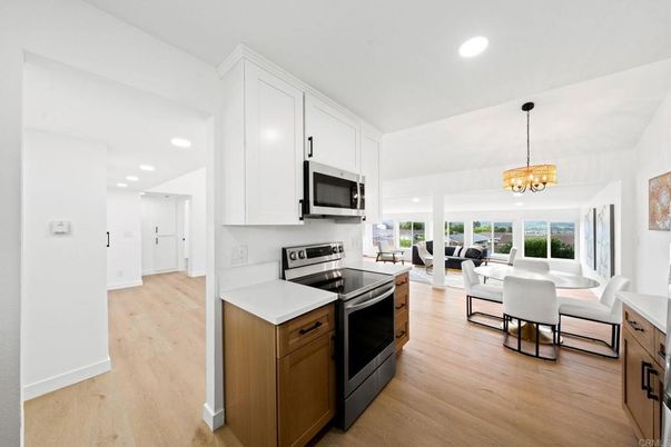 Chandelier, Dining room, Interior, Kitchen, Living room, Pendant Lights, Recessed Lighting, Stainless Steel Appliances, Wood Texture Flooring