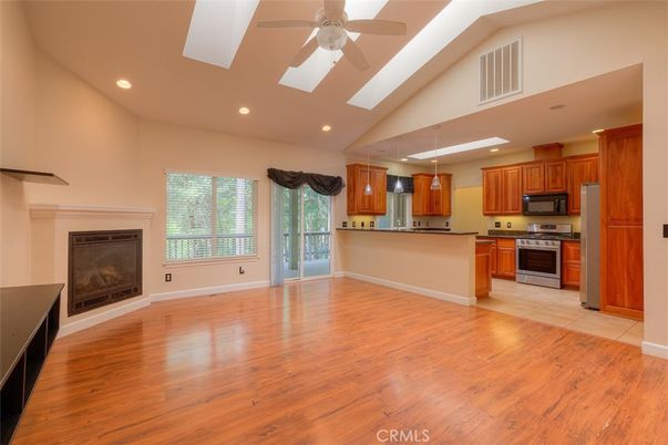 Empty room, Fireplace, Interior, Kitchen, Pendant Lights, Recessed Lighting, Stainless Steel Appliances, Wood Texture Flooring
