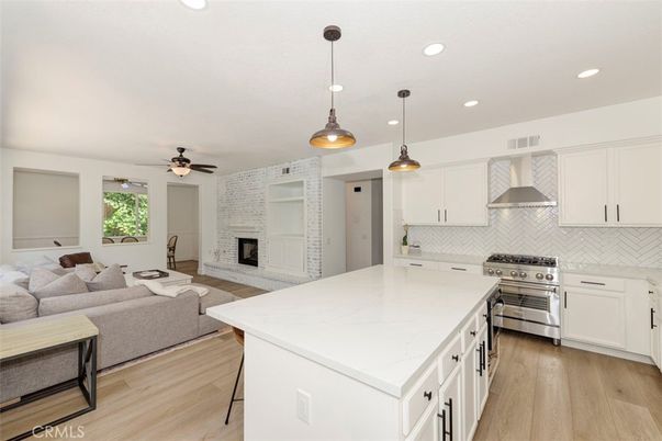 Fireplace, Interior, Kitchen, Living room, Pendant Lights, Recessed Lighting, Stainless Steel Appliances, Stone Walls, Wood Texture Flooring