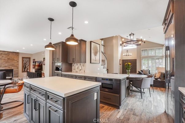 Chandelier, Dining room, Fireplace, Interior, Kitchen, Living room, Pendant Lights, Recessed Lighting, Stainless Steel Appliances, Stone Walls, Wood Texture Flooring