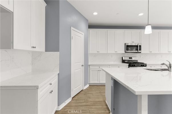 Interior, Kitchen, Marble Walls, Pendant Lights, Recessed Lighting, Stainless Steel Appliances, Wood Texture Flooring