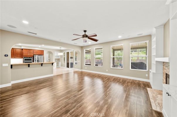 Empty room, Fireplace, Interior, Kitchen, Pendant Lights, Recessed Lighting, Stainless Steel Appliances, Wood Texture Flooring