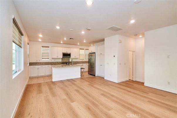 Empty room, Interior, Kitchen, Recessed Lighting, Stainless Steel Appliances, Wood Texture Flooring