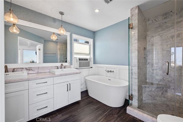 Bathroom, Dual Sink Vanities, Free Standing Baths, Glass Shower, Interior, Marble Walls, Pendant Lights, Recessed Lighting, Wood Texture Flooring