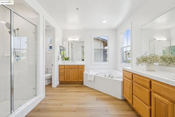 Bathroom, Dual Sink Vanities, Glass Shower, Interior, Recessed Lighting, Tile Countertops, Wood Texture Flooring