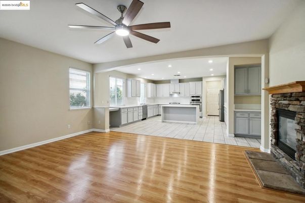 Empty room, Fireplace, Interior, Kitchen, Recessed Lighting, Stainless Steel Appliances, Wood Texture Flooring