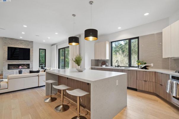 Fireplace, Interior, Kitchen, Living room, Pendant Lights, Recessed Lighting, Stainless Steel Appliances, Stone Walls, Wood Texture Flooring