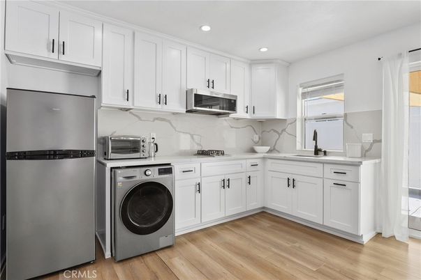Interior, Kitchen, Marble Walls, Recessed Lighting, Washer, Wood Texture Flooring