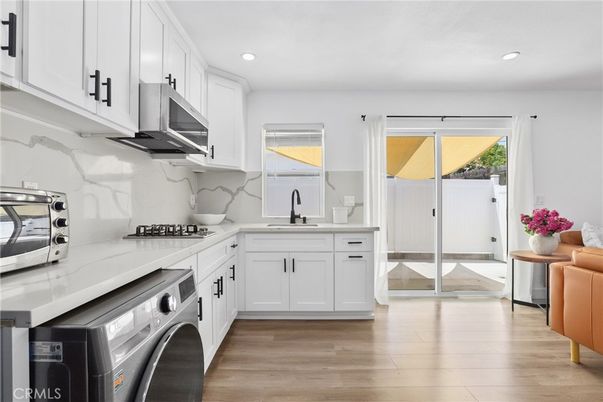 Interior, Kitchen, Marble Walls, Recessed Lighting, Stainless Steel Appliances, Washer, Wood Texture Flooring