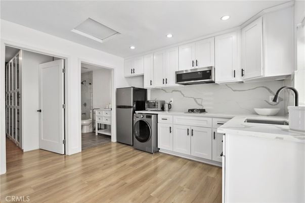 Interior, Kitchen, Marble Walls, Recessed Lighting, Washer, Wood Texture Flooring
