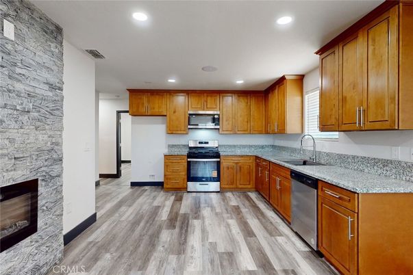 Fireplace, Interior, Kitchen, Recessed Lighting, Stainless Steel Appliances, Stone Walls, Wood Texture Flooring