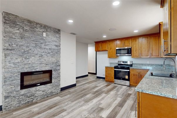 Fireplace, Interior, Kitchen, Recessed Lighting, Stainless Steel Appliances, Stone Walls, Wood Texture Flooring