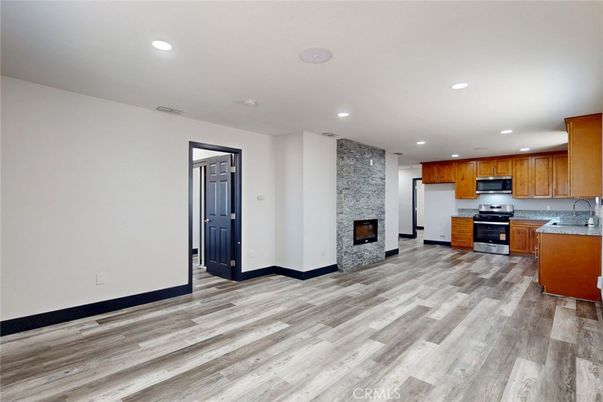 Fireplace, Interior, Kitchen, Recessed Lighting, Stainless Steel Appliances, Stone Walls, Wood Texture Flooring