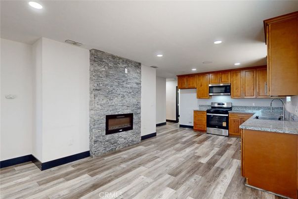 Fireplace, Interior, Kitchen, Recessed Lighting, Stainless Steel Appliances, Stone Walls, Wood Texture Flooring